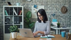 Femme travaillant à distance sur son ordinateur pour manager à distance